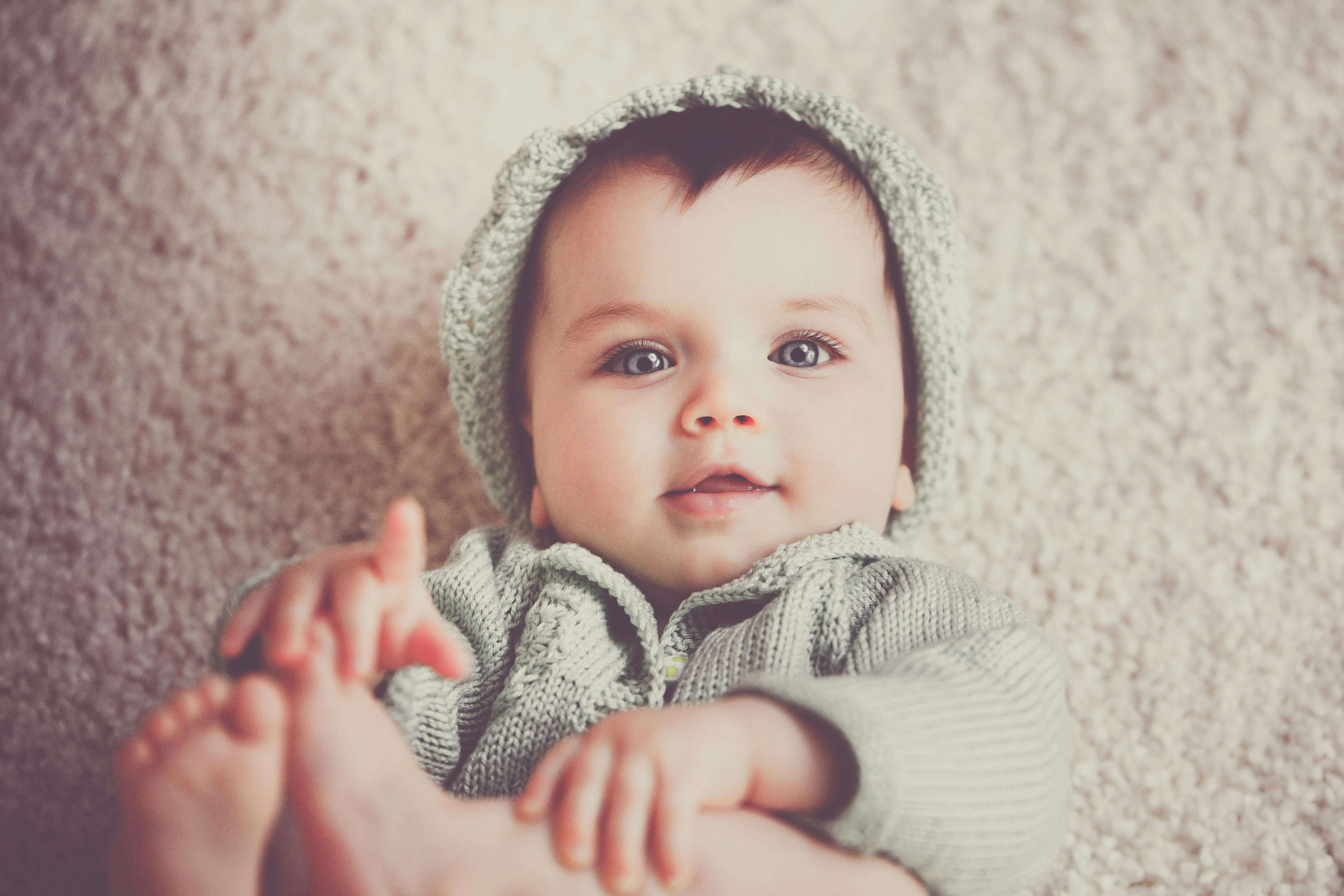 Baby boy holding his feet.