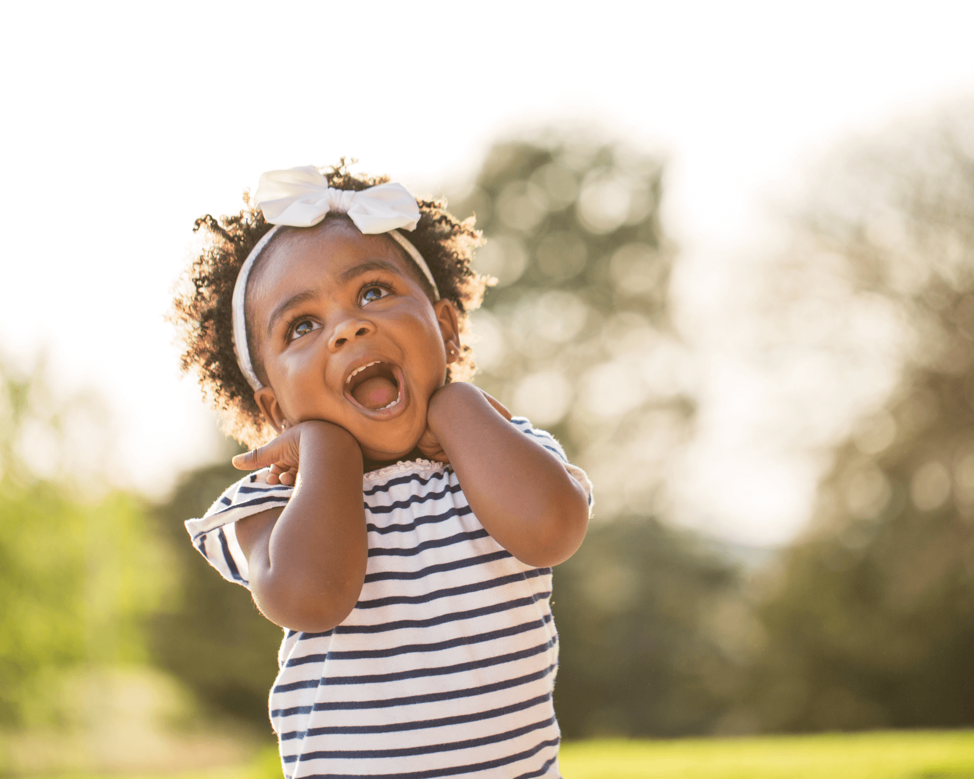 Happy baby girl wearing a striped shirt.