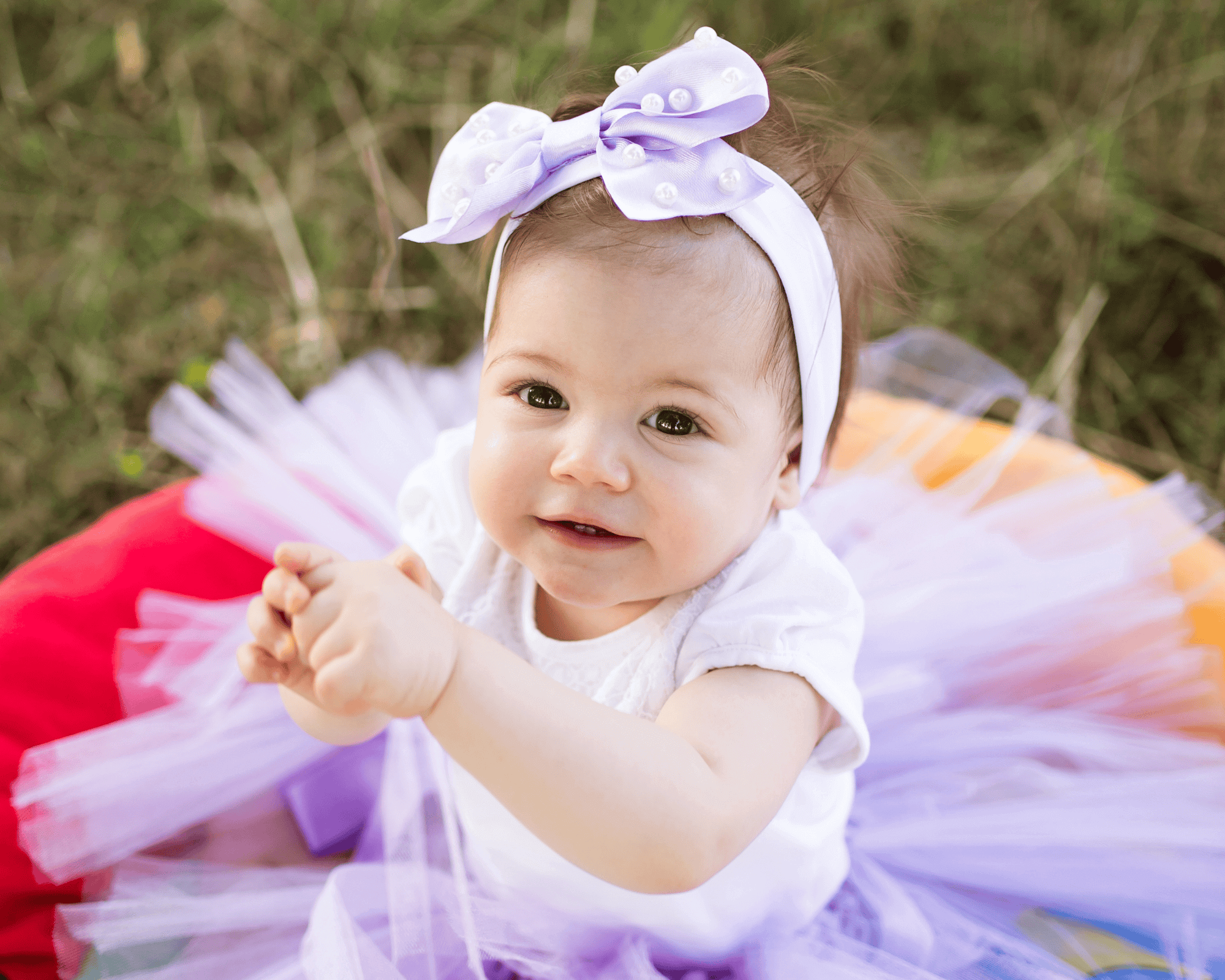 Baby wearing a mauve dress.