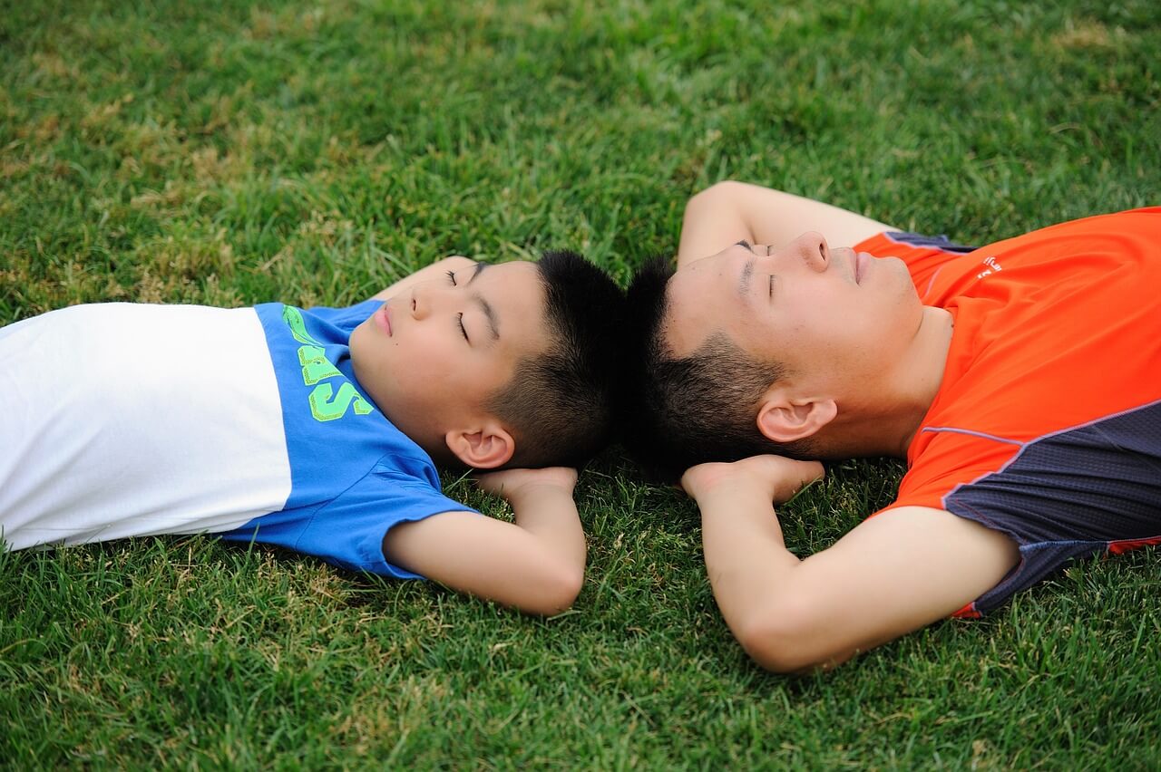 Dad and son lying in the grass