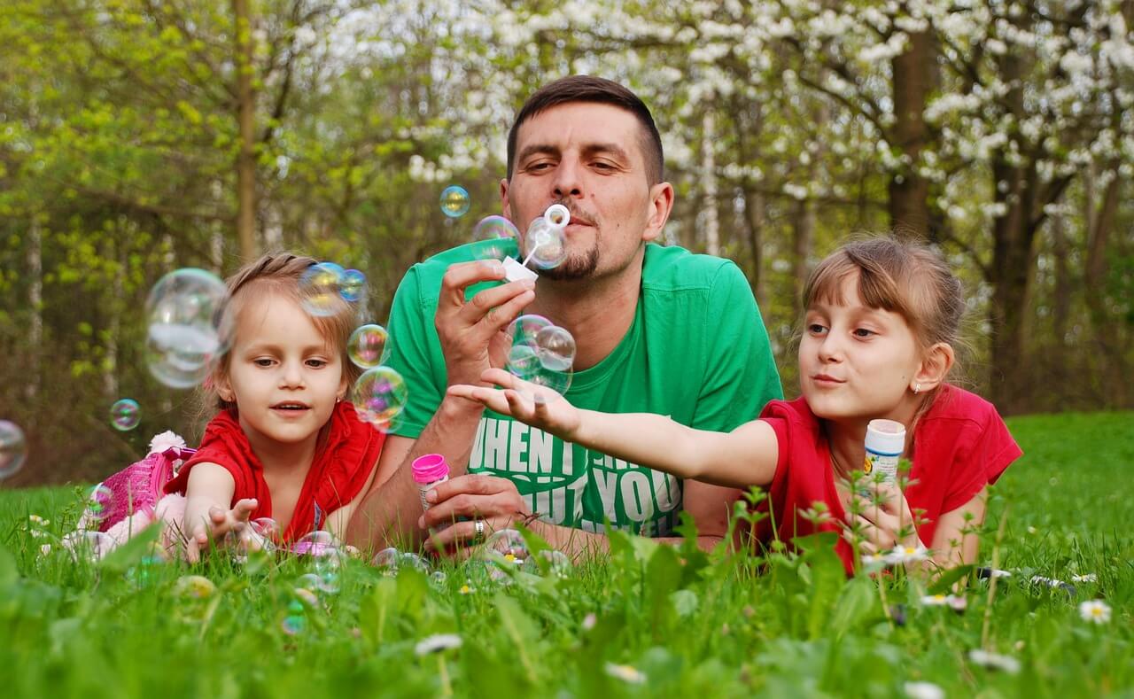 Dad and two girls blowing bubbles