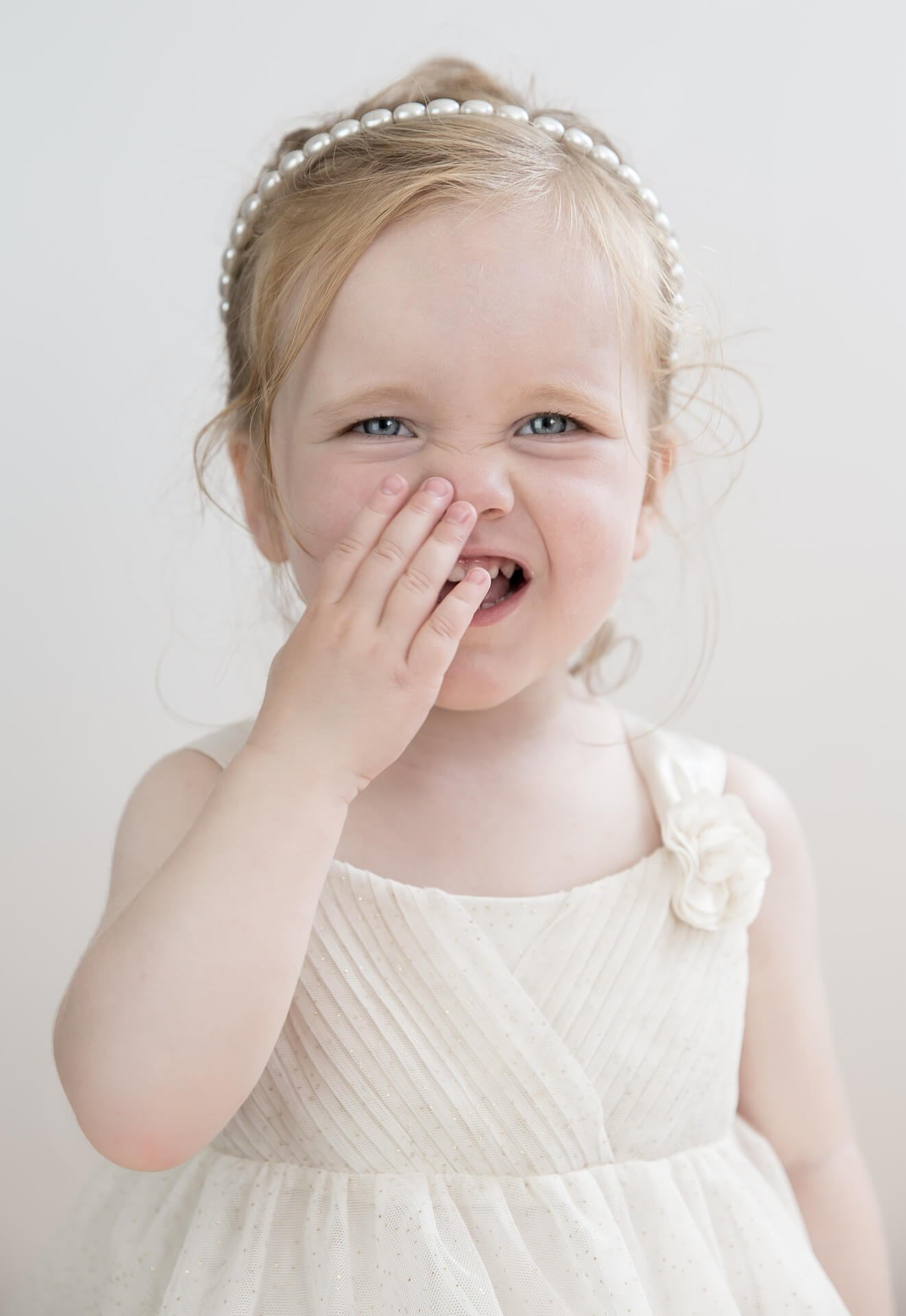 Female Toddler with Hand on Her Mouth