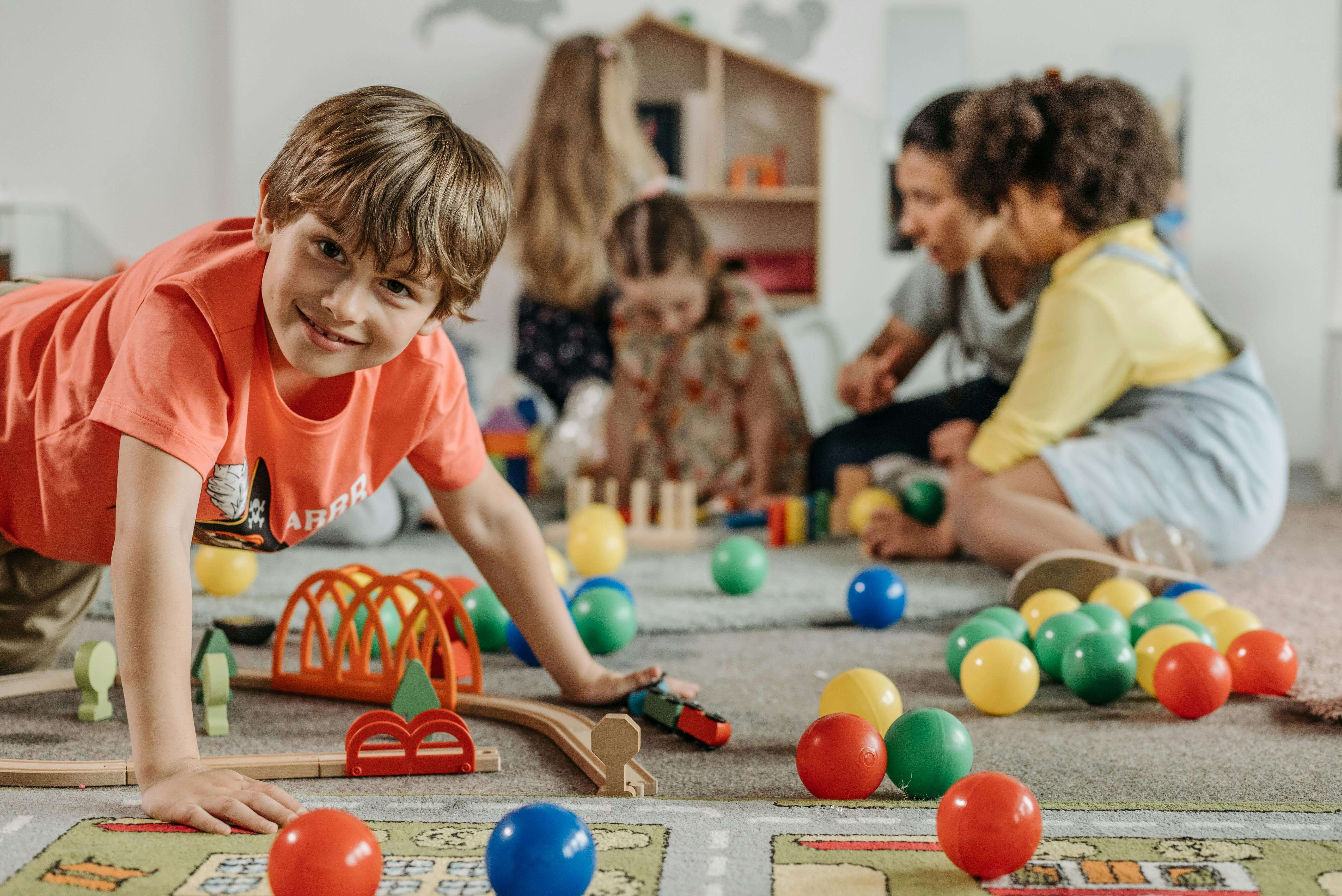 Kids at preschool, playing on floor.