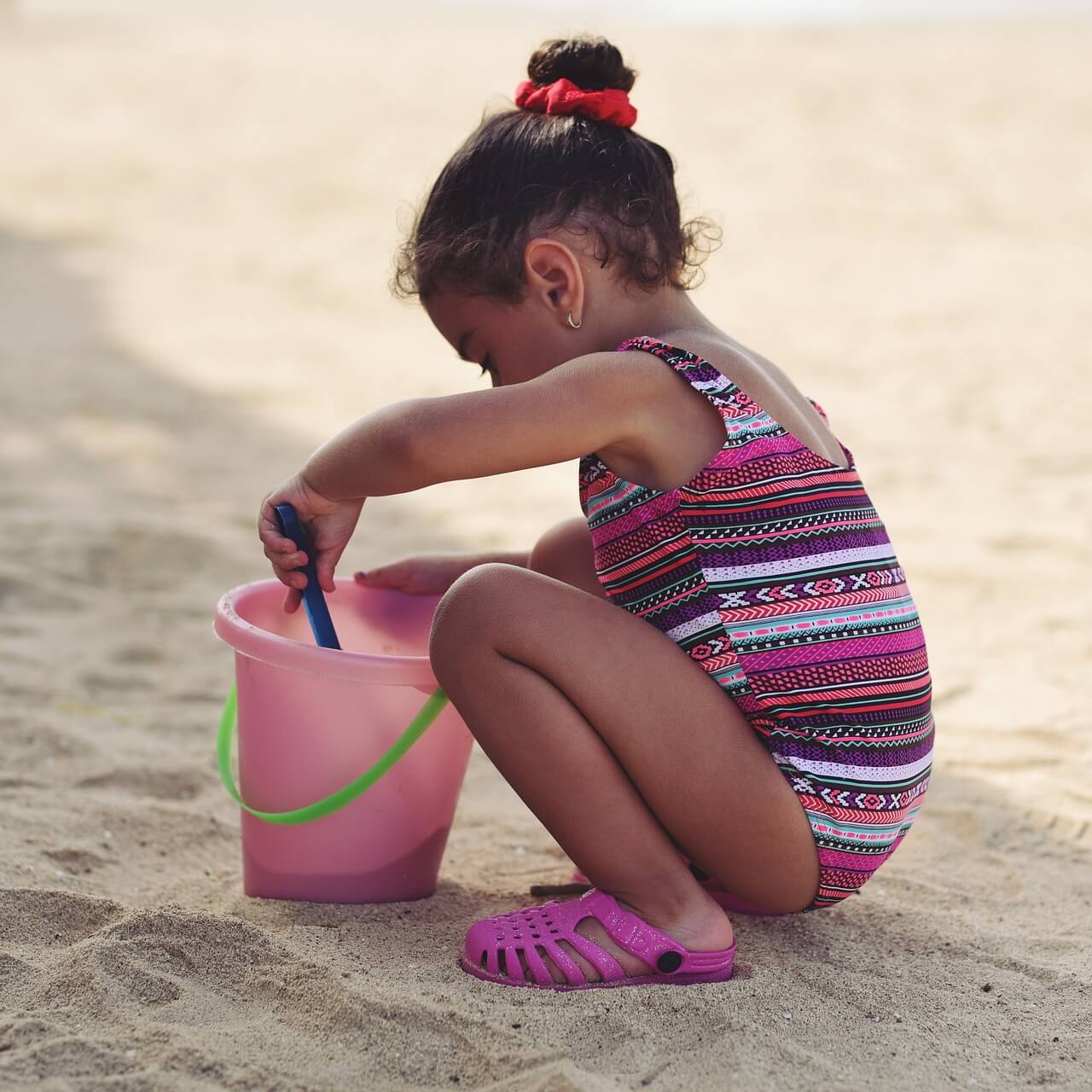 Little girl on beach exploring and digging. 