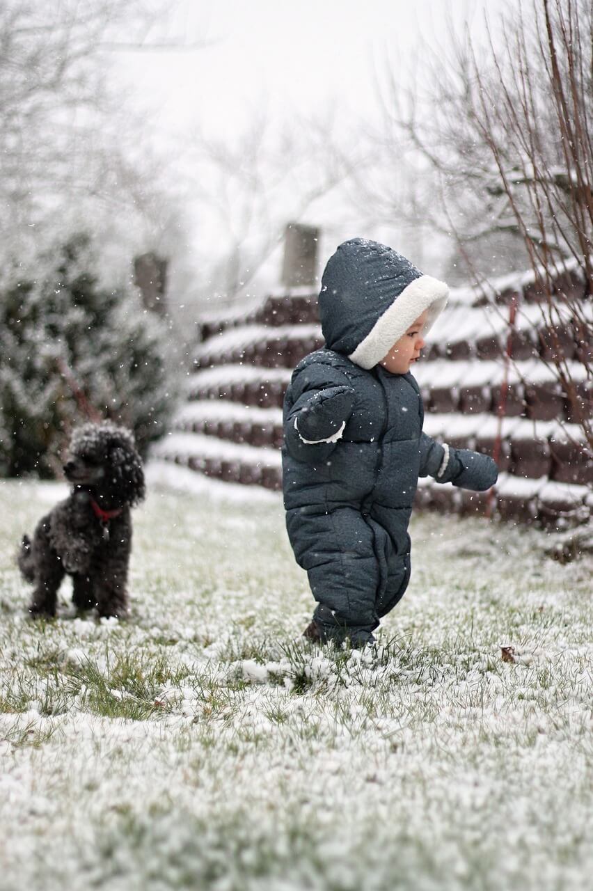 Toddler outside wtih dog in winter. 