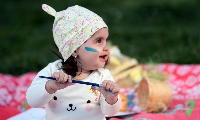 toddler painting outdoors