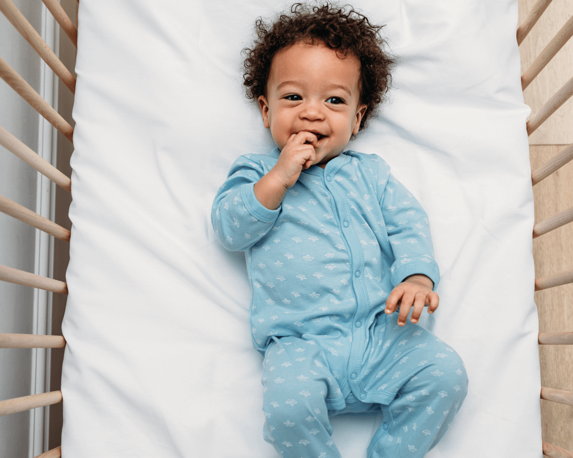 Baby boy happily in crib.