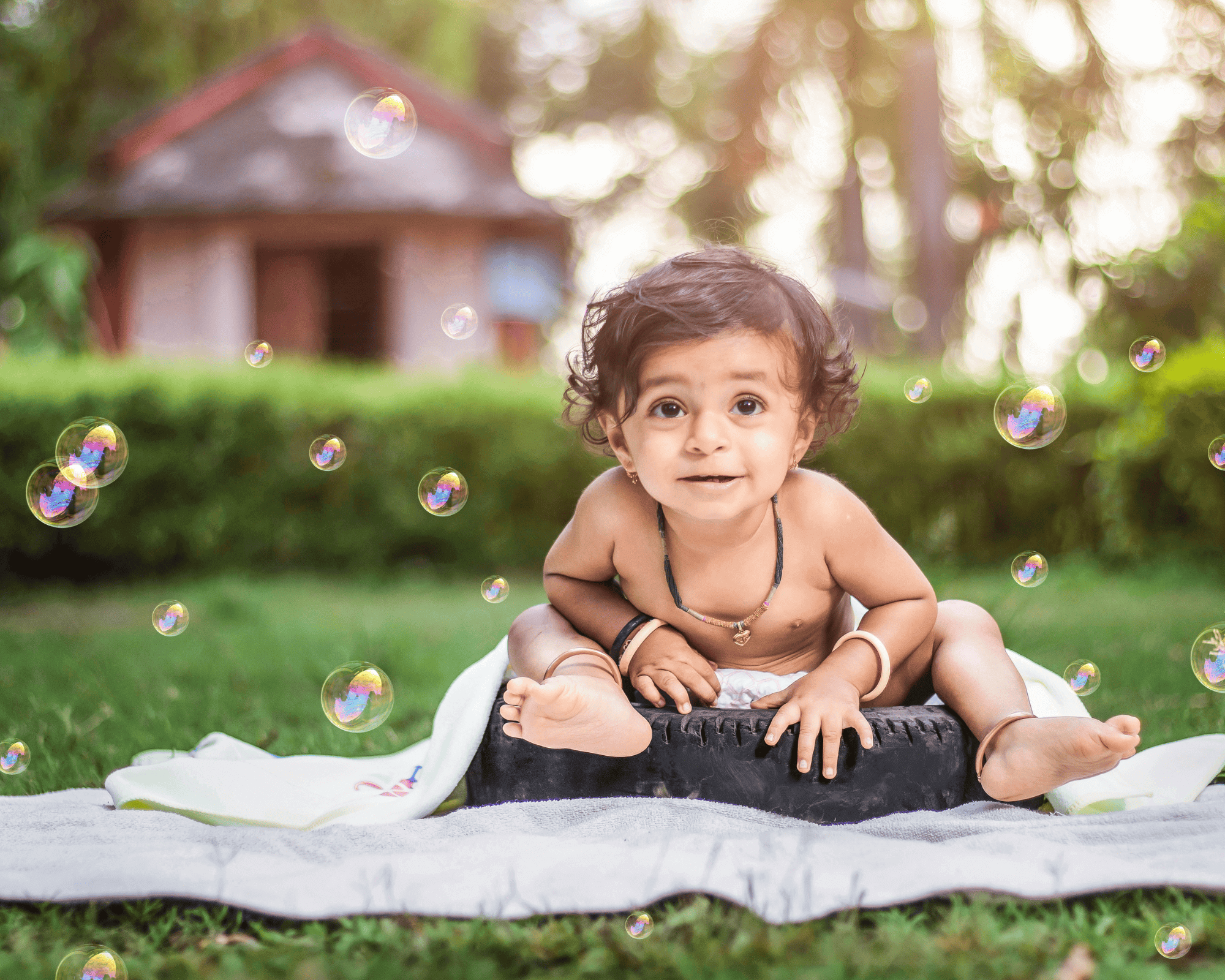 baby boy sitting on blankey outside