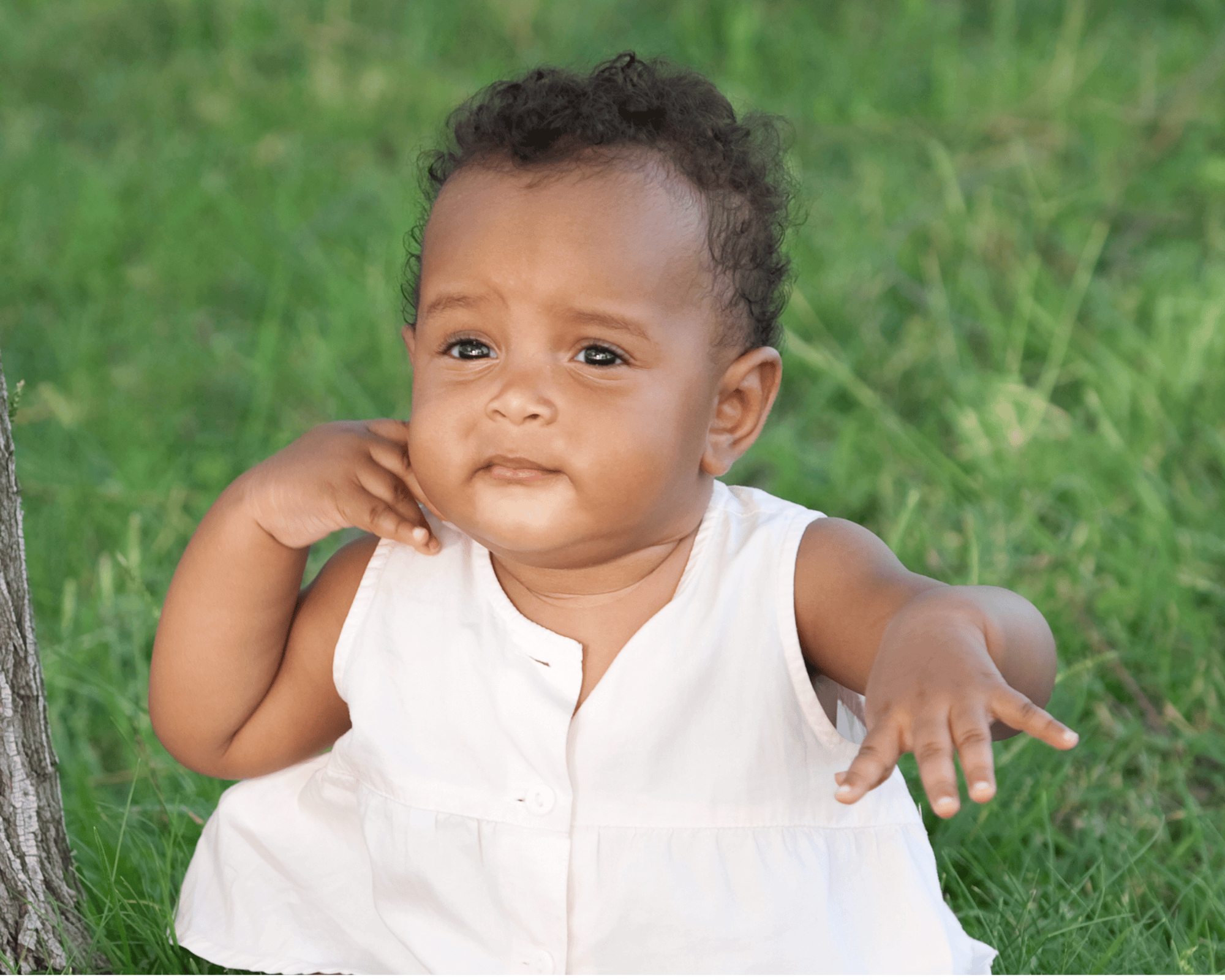 Baby girl outside in nature looking excited.