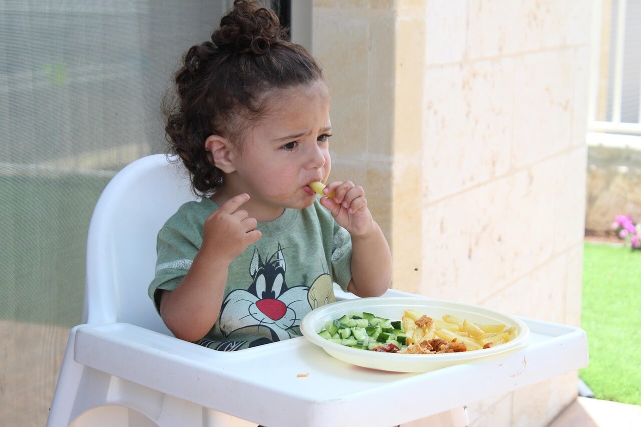 Female toddler eating a healthy meal. 