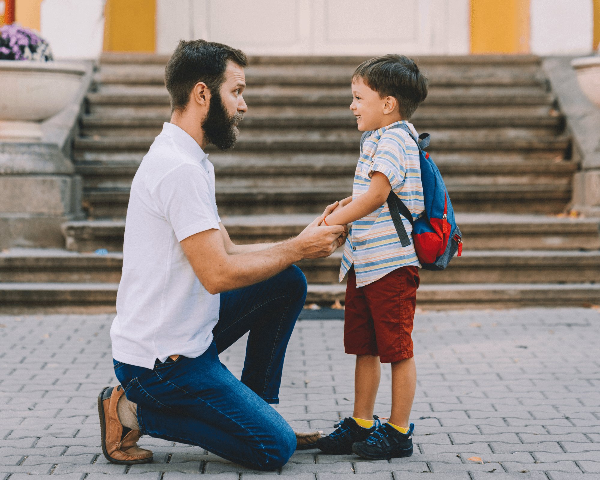 Dad and son talking at the bottom of steps.