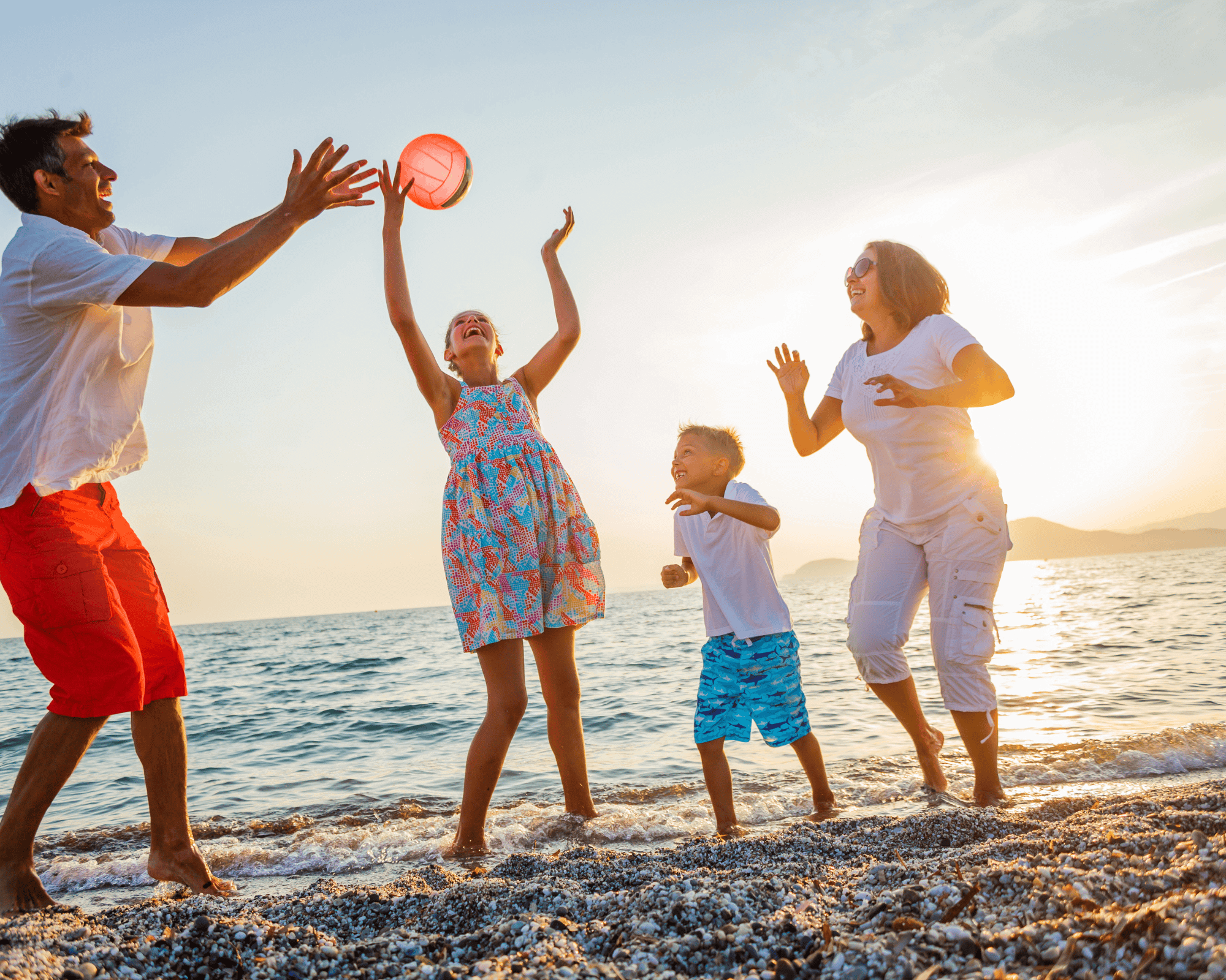 Family playing frizbee at the beach.