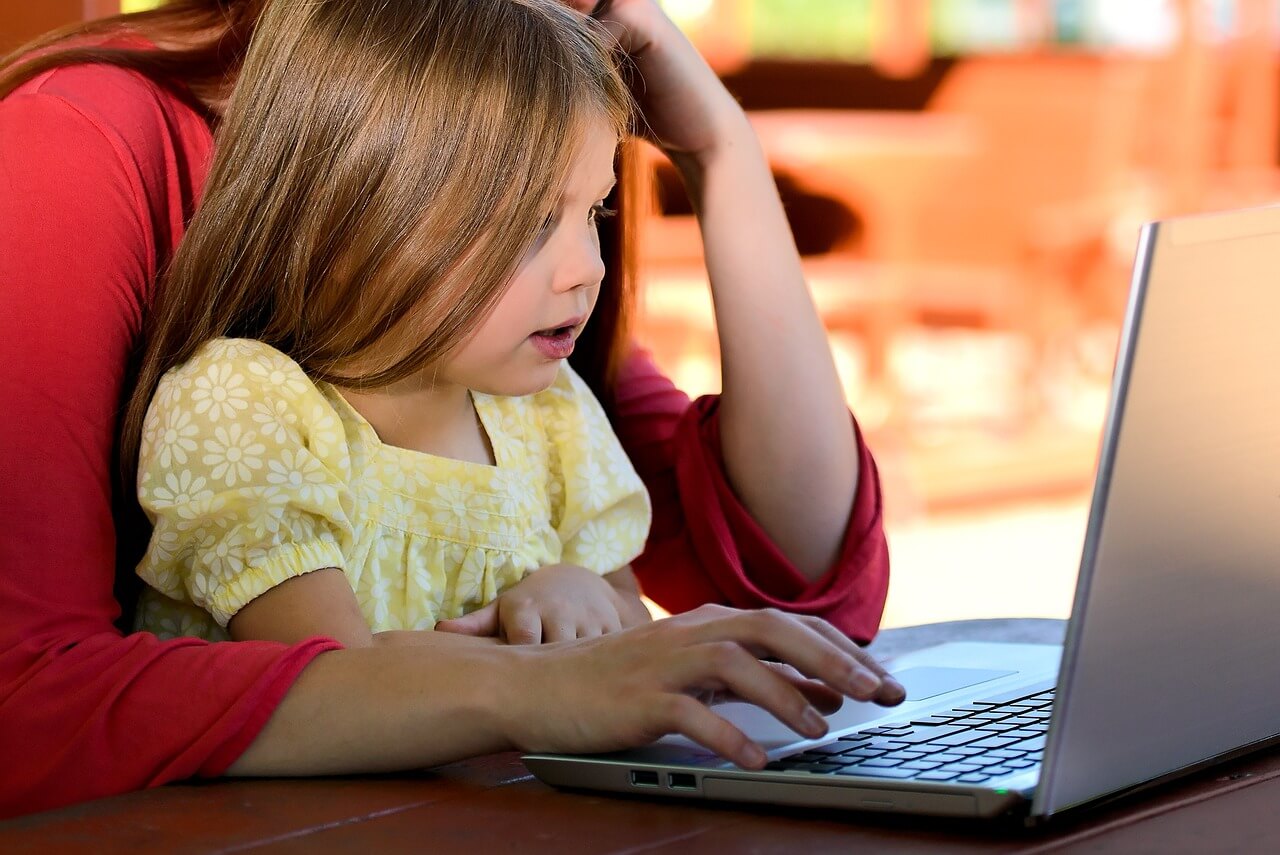 Mom working from home with daughter on lap.