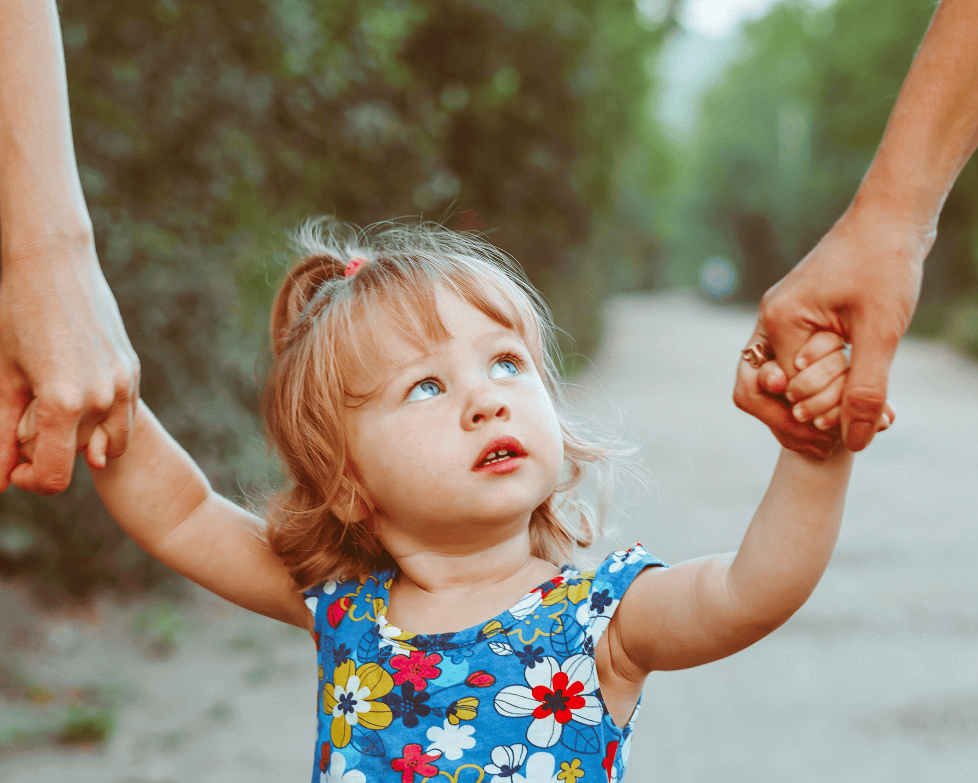 Parents holding daughters hands. 